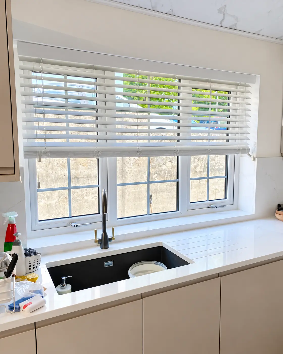 White Venetian blinds fitted above a kitchen window in Bradford